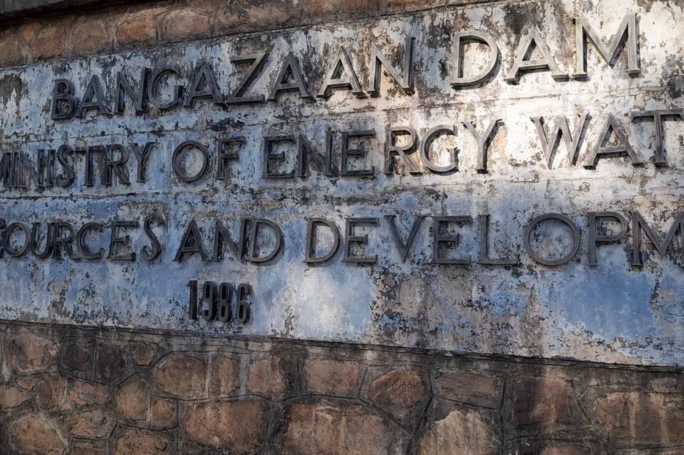 Cast inscription on the dam wall reading Bangazaan Dam, Ministry of Energy, Water Resources and Development, 1986